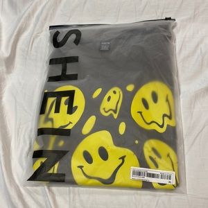 This is a brown tshirt with yellow smily faces all over